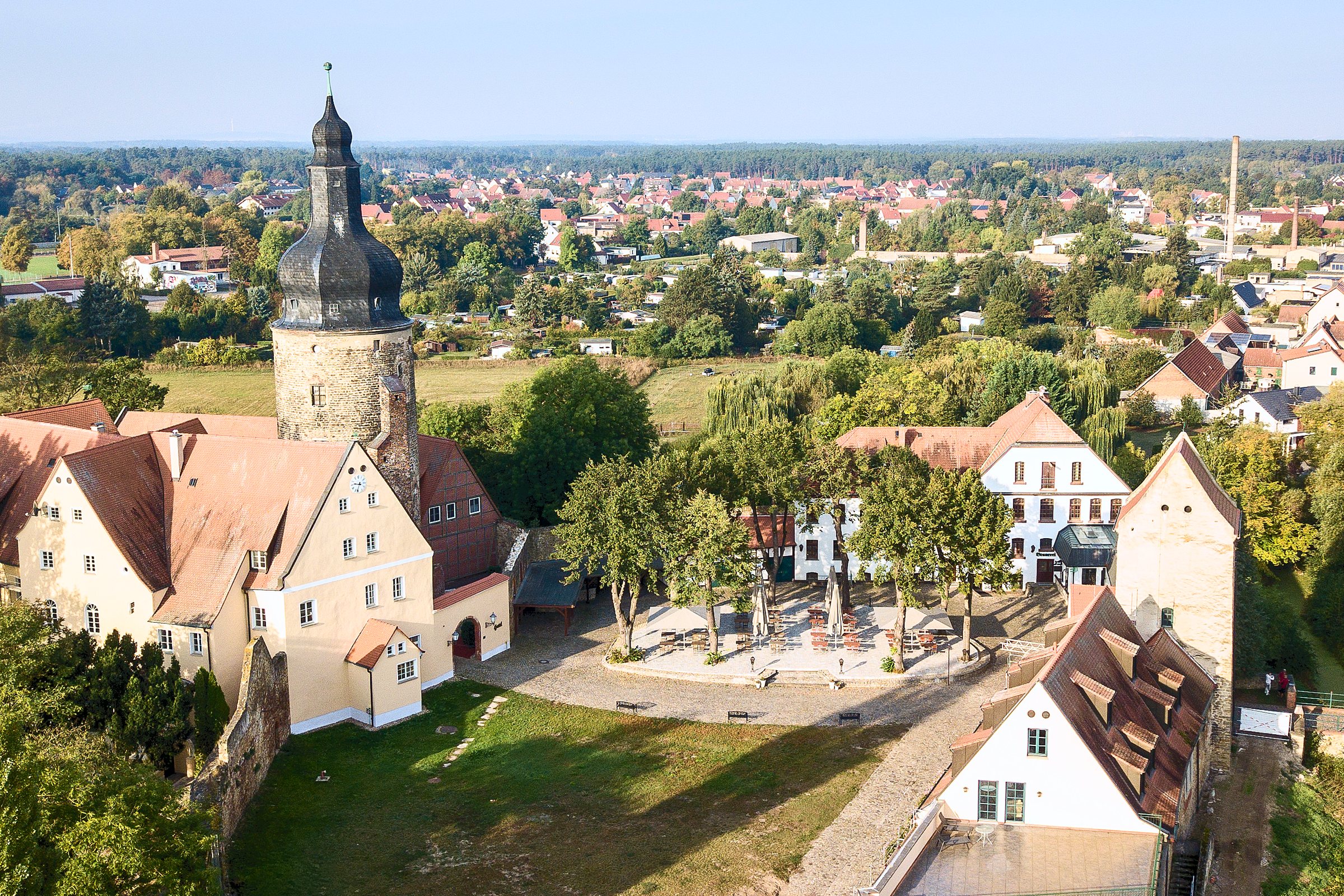 Schräge Luftaufnahme der Wasserburg Gommern mit Turm, Innenhof und Biergarten